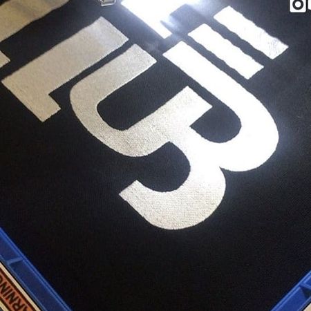 Logoservice - Weißer Schriftzuck auf einem schwarzen Stoff genäht