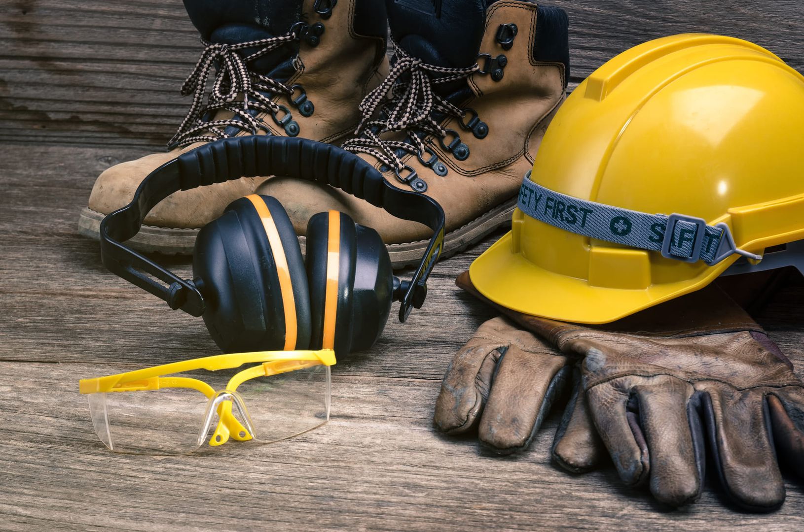 Eine Schutzbrille, Handschuhe und ein Helm, bereit für den Einsatz im Sicherheitsbereich.